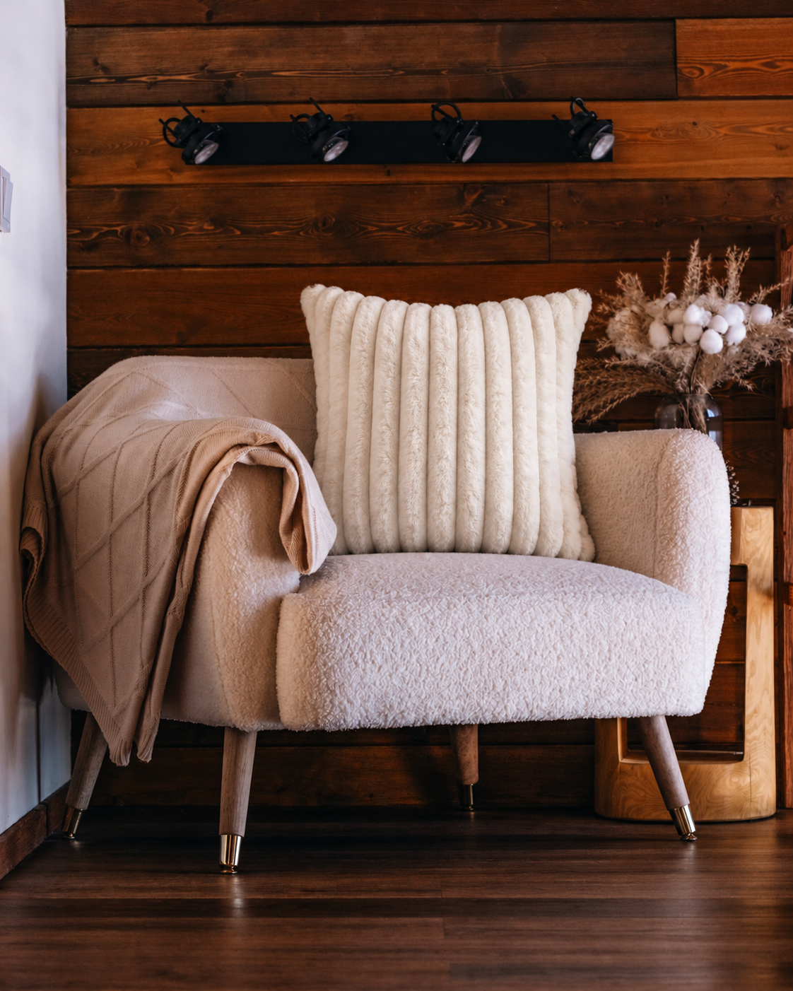 Channel Faux Fur Pillow Cover in Ivory, on a rattan armchair