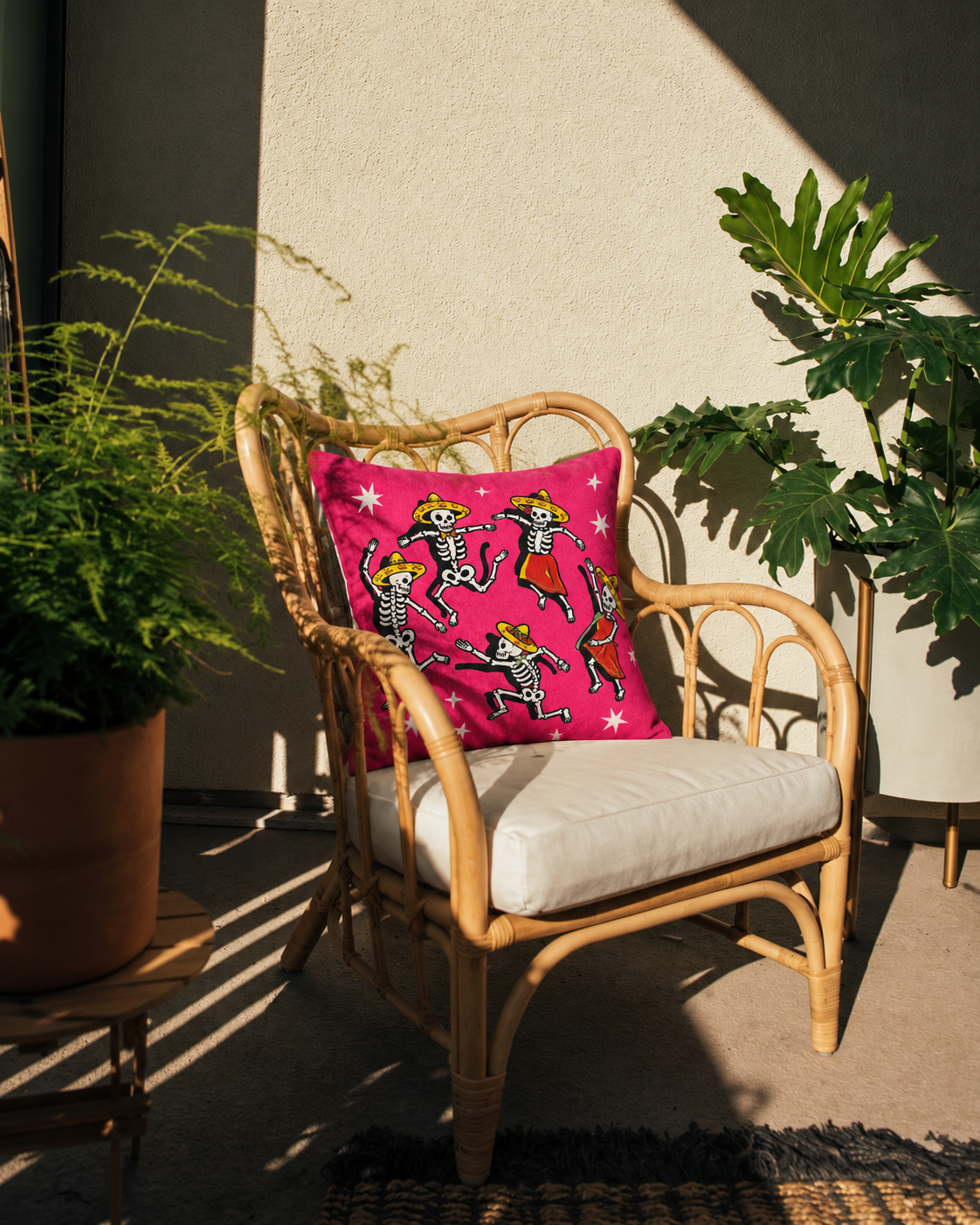 Dancing Skeletons Cotton Velvet Pillow Cover, on a rattan armchair