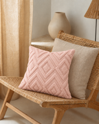 Diamond Tufted Cotton Pillow Cover in Blush, on a rattan armchair