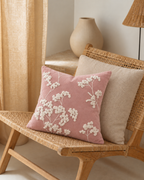 Embroidered Sprig Cotton Velvet Pillow Cover in Rose, on a rattan armchair