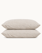 French Linen Pillowcases, one case on a pillow and one folded, on a plain background