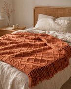 Fringed Knit Throw — on a made bed, morning light