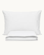 Cotton Percale Pillowcases, one case on a pillow, one folded, on a plain background