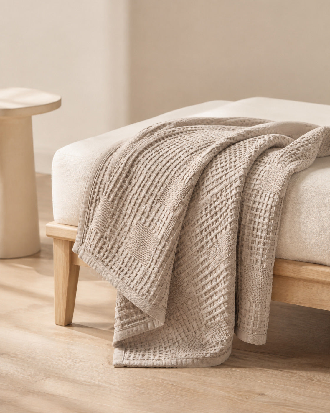 Waffle Knit Throw, draped over the end of a bed
