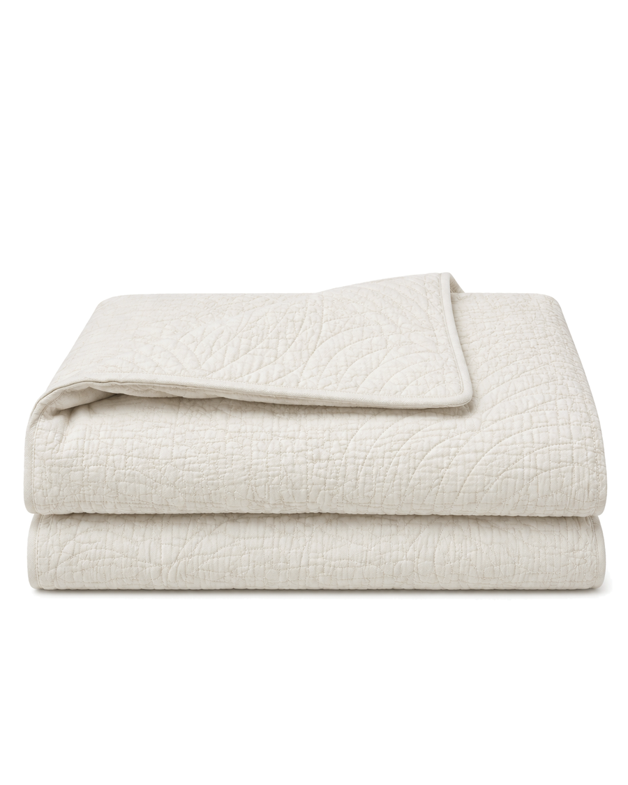 Quilted Cotton Coverlet, folded with one corner turned to show both faces, on a plain background