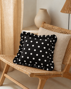 Ruffled Polka Dot Cotton Sateen Pillow Cover, on a rattan armchair