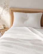 Waffle Cotton Coverlet — on a made bed, morning light